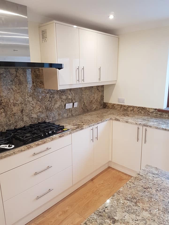 Finished white kitchen with granite worktops, upstands and fitted gas hob