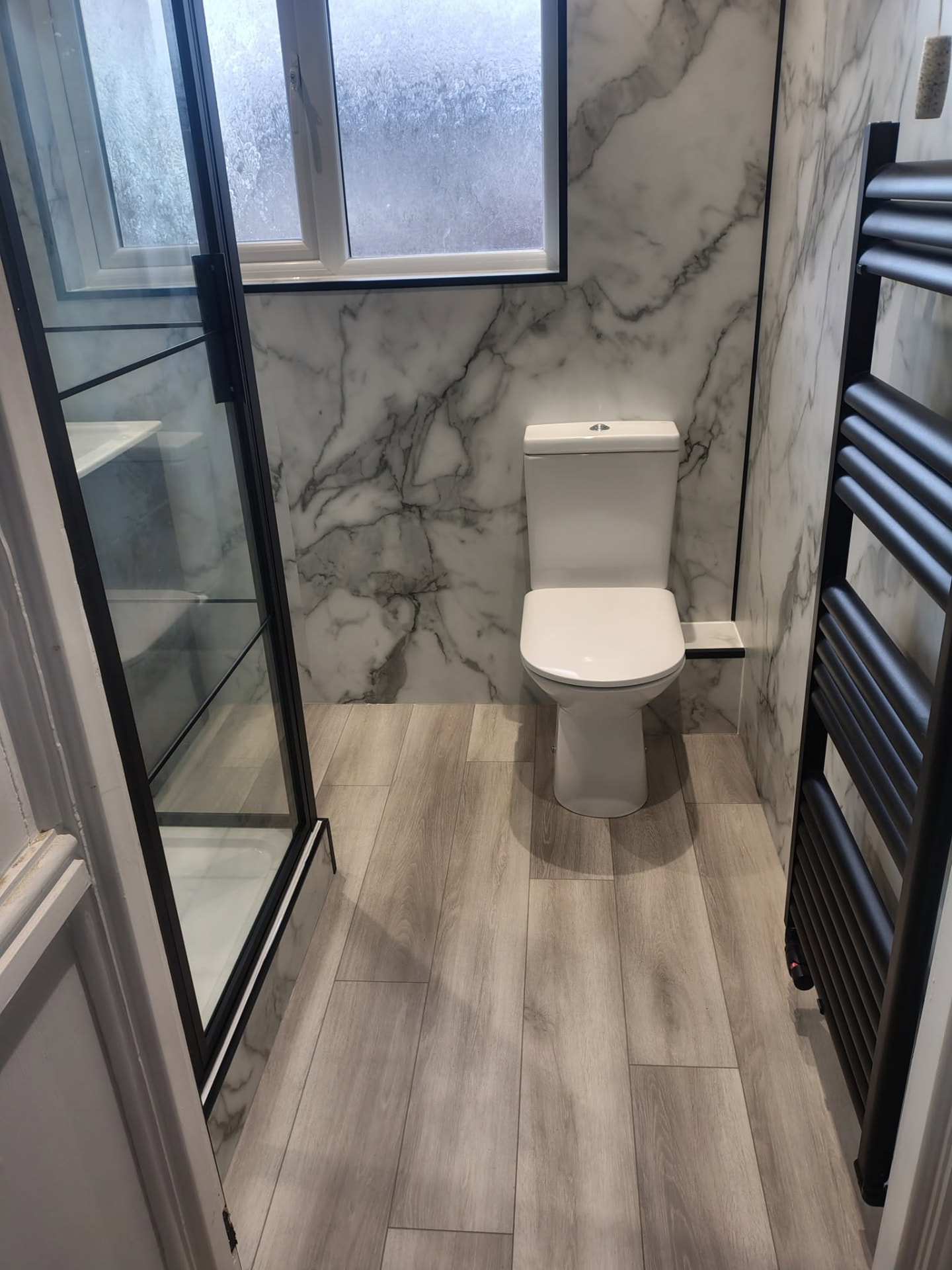 Marble effect bathroom with black shower frame